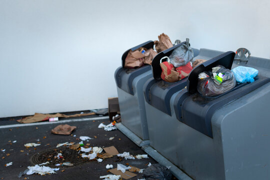 Trash spilling from garbage bins at street