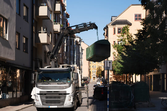 Garbage truck picking up bin at street in city