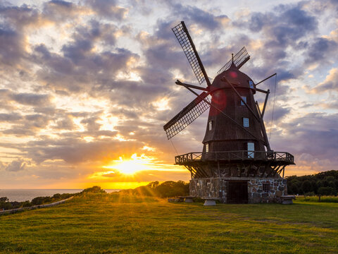 Beautiful sunset with windmill in farm