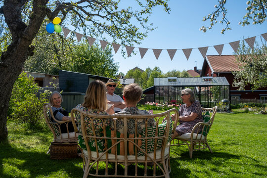 Family spending leisure time while sitting on sofa in decorated back yard