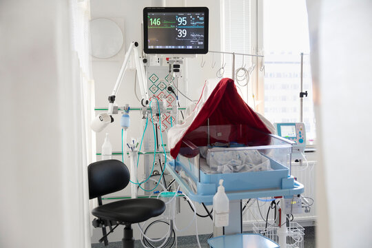 Readings on heart rate monitor with baby crib in clinic at hospital
