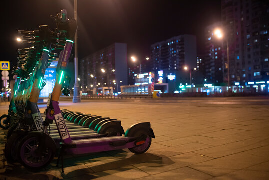 Moscow, Russia. March 21, 2025. Rental point purple electric scooters at night	