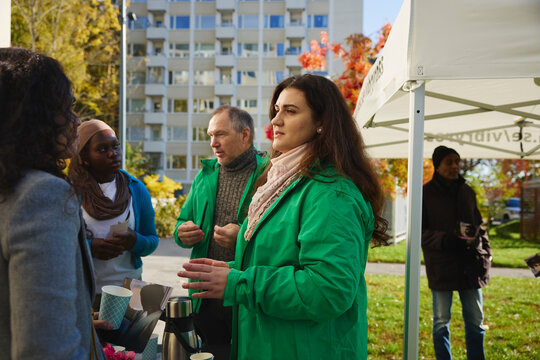 Female charity volunteer talking with woman about mental health program to woman at park