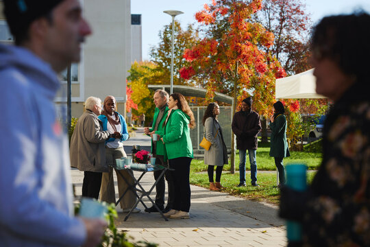 Male and female volunteers discussing about charity work with neighbors at public park