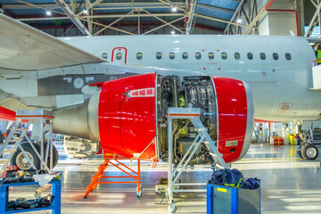 Open engine cowling of airplane in hangar, repair and maintenance in civil aviation, side view of...