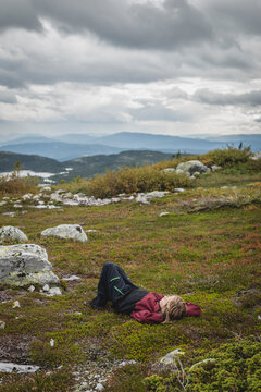 Carefree woman relaxing while lying down on hill