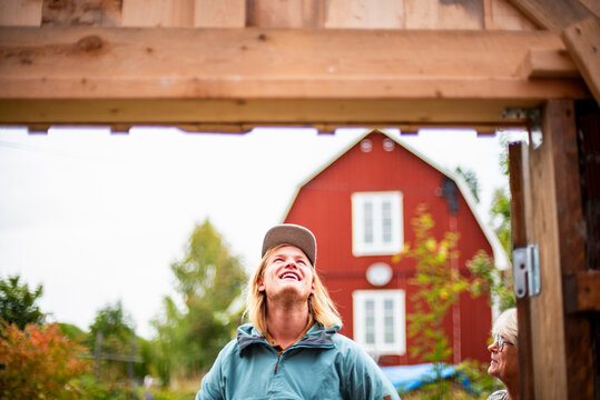 Happy young man looking at construction frame with mother
