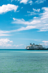 青空と透き通る海、桟橋に停泊するフェリー