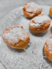 Delicious baursaki sprinkled with powdered sugar on glass plate in prague