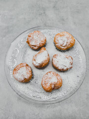 Delicious baursaki sprinkled with icing sugar on elegant glass plate in prague