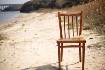 Empty wooden chair stands on the beach. Beautiful nature and background. Travel and leisure