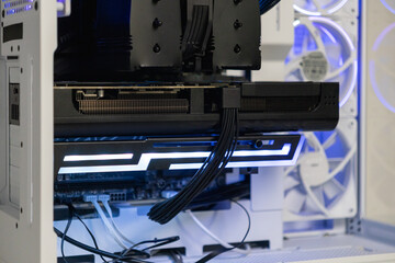 High-end graphics card installed in gaming PC with illuminated support bracket for secure mounting...
