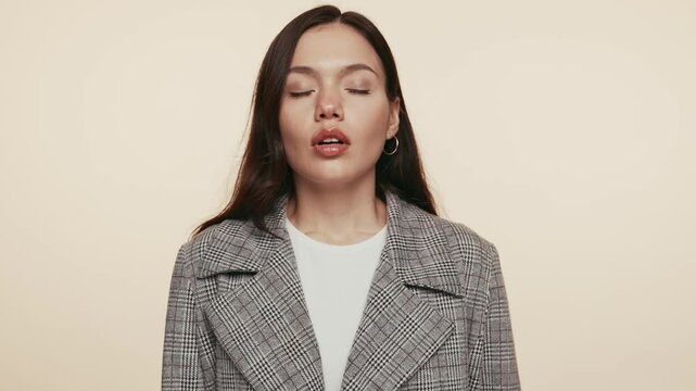 A serene woman in a plaid blazer practices breathing exercises for stress relief and tranquility.