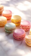 Obraz premium Delicate pastel macarons glistening under sunlight on marble surface