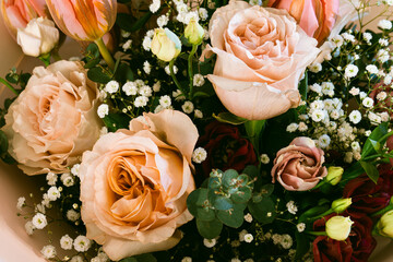 Elegant pastel flower bouquet with peach roses, tulips, eucalyptus, and baby's breath, romantic close-up macro for wedding or floral design background