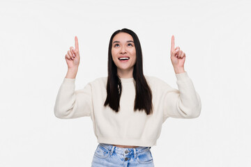 Positive Asian young woman girl female student in casual outfit points with both fore index fingers...