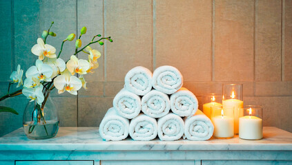 Spa serenity with towels, candles and orchids.