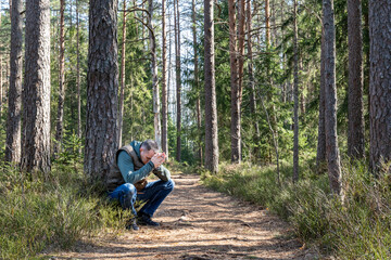 Person in Deep Emotional Pain Sitting Alone in Pine Forest – Symbol of Mental Health Struggles,...
