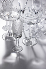 Empty crystal champagne glasses of different shapes. Wine and cocktail glasses. Shallow depth of field