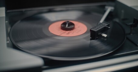 Vinyl Record Spinning On Vintage Turntable. Needle Gently Scratching Grooves, Playing Classic Music or Analog Sound on Vinyl Record Player. Retro Sound System with Nostalgic Aesthetic. Macro Close Up.