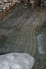 geology river bank rock water strata and layer