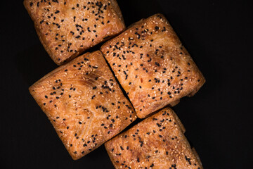Puff pastry samsa with meat on a black background, top view