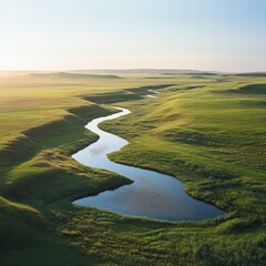 A large grassy plain with a quiet, flowing river cutting through it, the sunlight creating natural reflections on the water s surface, and the grass surrounding the river swaying in the wind