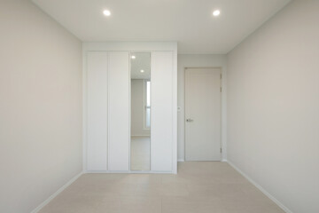 A clean room with white interior and white furniture