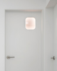 Install a window in the door so you can see if the bathroom is lit