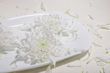 Part of a white plate on which beautiful white flowers lie