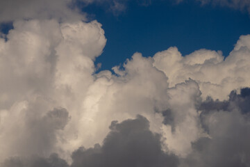 Background with cloudy skies. Cumulus clouds in sky. Blue cloudscape. Sky background. Cloudy sky with sunlight. White clouds background. Blue sky and white clouds background.