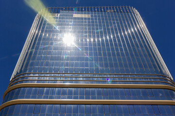 Bright sun reflecting in the windows of a tall skyscraper. Bright white flash, climate change...