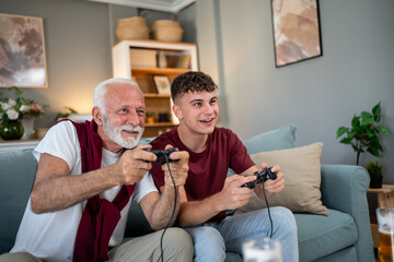 Grandfather and grandson playing videogames at home