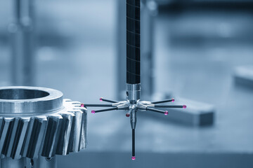 The CMM machine measuring the metal gear parts by modular probe in the light blue scene.
