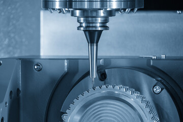 The 5-axis CNC milling machine cutting the gear part with solid ball nose end mill tool in the light blue scene.