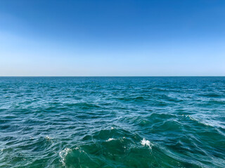 tranquil seascape with clear turquoise water on clear sky background with copy space. straight horizon. harmonious nature colors. close up