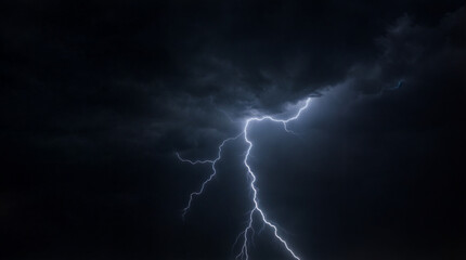 A bolt of lightning strikes the sky, illuminating the darkness