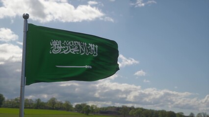 Flag of Saudi Arabia waving in the wind, sky and sun background. 3d illustration
