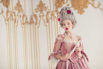 Elegant woman in historical costume holding a fan, embodying a blend of past and present fashion elements
