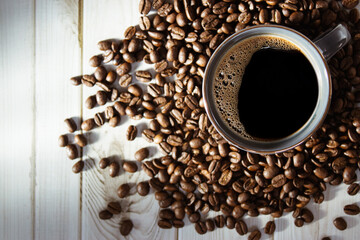 A cozy cup of coffee on a wooden table, with beans . A perfect scene for coffee lovers.
