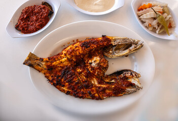 Spicy grilled grouper with a crispy charred surface, served in an Arabic restaurant in the UAE