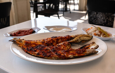 Spicy grilled grouper with a crispy charred surface, served in an Arabic restaurant in the UAE