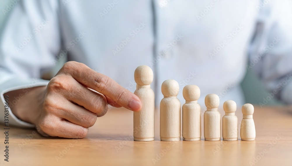 Poster a hand is pointing at wooden figures of different sizes. the figures are arranged in a row on a wood
