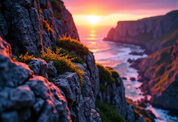 Vibrant sunset over rocky cliffs with lush greenery along the coastline