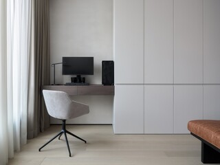 Comfortable workplace with computer near wooden wall in stylish room interior. Home office design