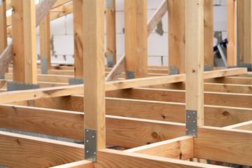 Making a wooden roof. Close-up wooden roof trusses in a frame structure. Steel beam connections....