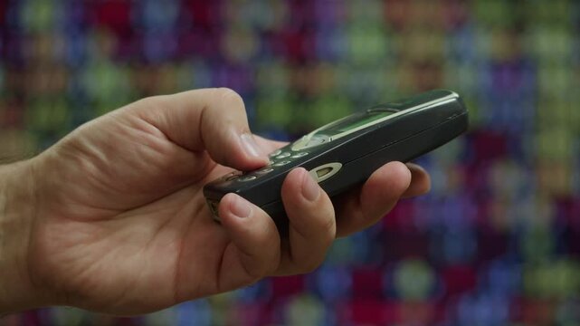 80s 90s retro vintage cell phone being used by a young adult woman, taking old mobile phone with antenna from jeans pocket.