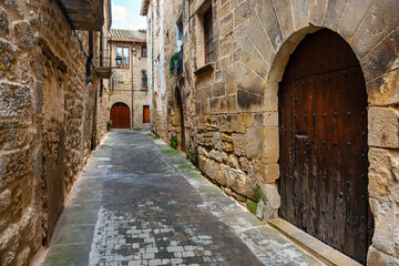 Fototapeta premium Narrow and picturesque alleys of very old stone houses in the pretty village of Cretas, Teruel.