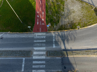 An aerial view of a pedestrian crosswalk connecting a bicycle lane, surrounded by urban...