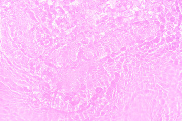 Fototapeta premium Pink water bubbles on the surface ripples. Defocus blurred transparent pink colored clear calm water surface texture with splash and bubbles. Water waves with shining pattern texture background